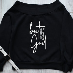 May include: Black off-the-shoulder sweatshirt with the text "but God" in white. The text is accompanied by the phrase "There was no way, but God made a way."