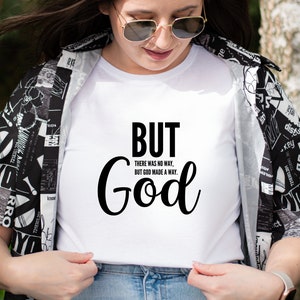 May include: White t-shirt with black text that reads "BUT THERE WAS NO WAY, BUT GOD MADE A WAY. God"