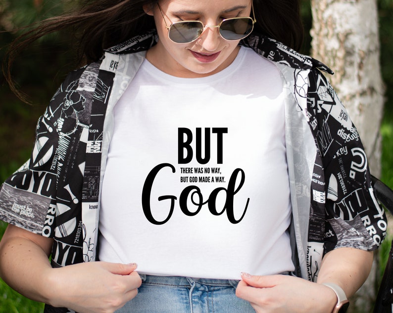 May include: White t-shirt with black text that reads "BUT THERE WAS NO WAY, BUT GOD MADE A WAY. God"