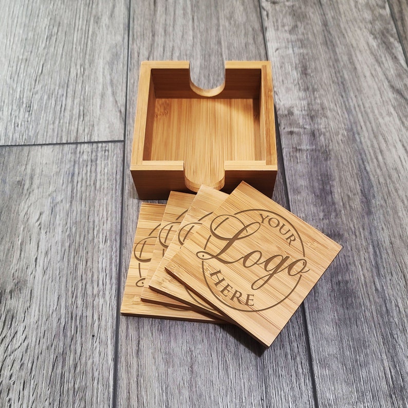 May include: Set of four bamboo coasters with a holder. The coasters are engraved with the words "Your Logo Here".