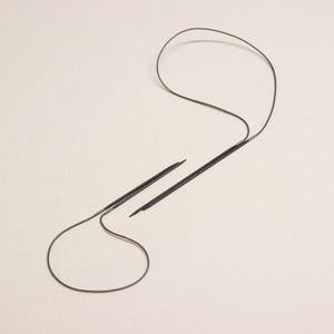 May include: A pair of black circular knitting needles with a cable connecting the two ends.