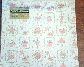 May include: A sheet of white gift wrap with a pink and green floral pattern. The wrap features small pink flowers, green leaves, birds, watering cans, and umbrellas. The text on the label reads "American Greetings Shower Gift Wraps 3-Sheets Approx. 20-30 25¢ Quality Bond Paper".