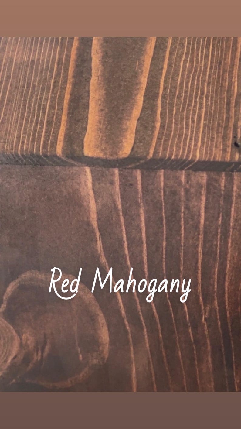 May include: Close-up of a wooden surface with a rich, reddish-brown hue. The wood grain is prominently displayed, with the text "Red Mahogany" in a cursive font. The wood has a warm, inviting appearance.