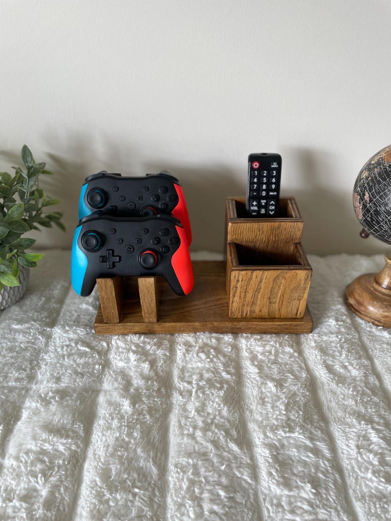 May include: A white ceramic mug with a black handle and the text "But First, Coffee" in a black, handwritten-style font. The mug is on a white surface.