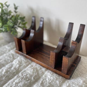 May include: A rustic wooden sign with the text "Welcome to our home" in white lettering. The sign has a distressed finish and a simple, inviting design, suitable for a front porch or entryway.