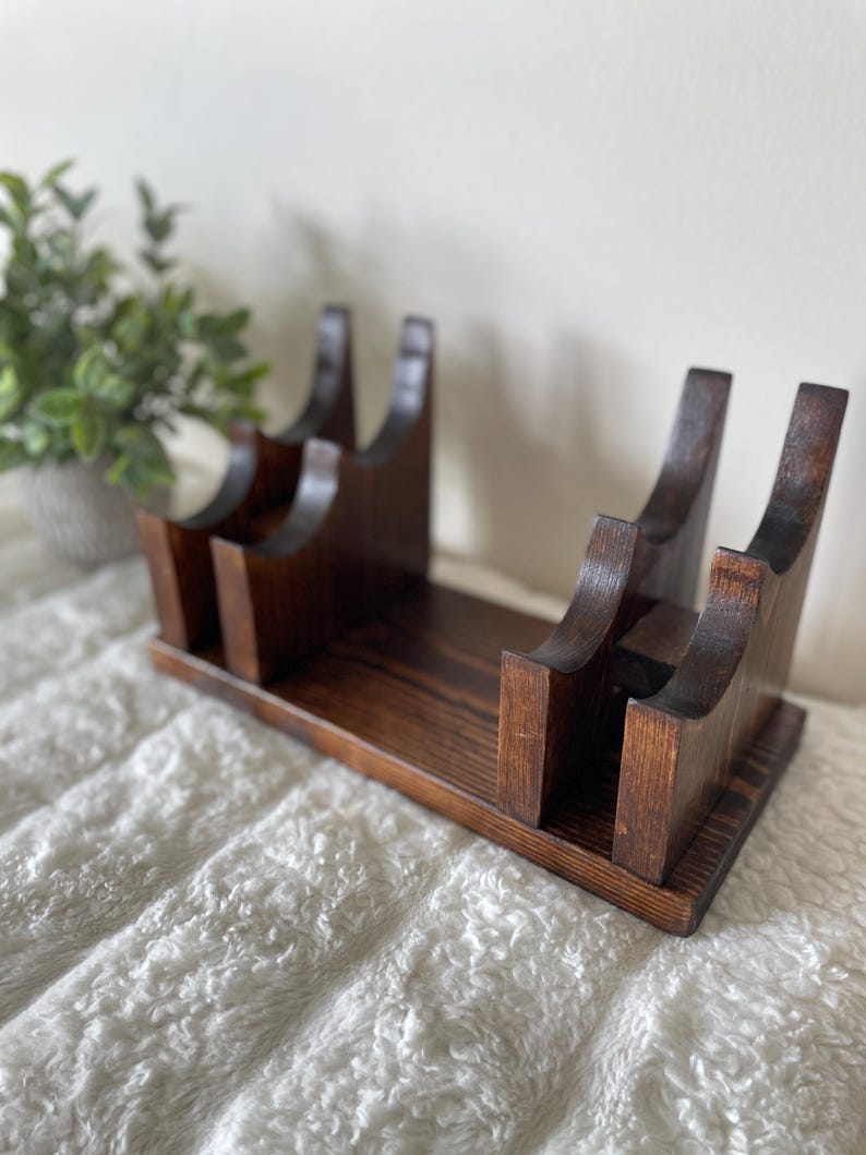 May include: A rustic wooden sign with the text "Welcome to our home" in white lettering. The sign has a distressed finish and a simple, inviting design, suitable for a front porch or entryway.