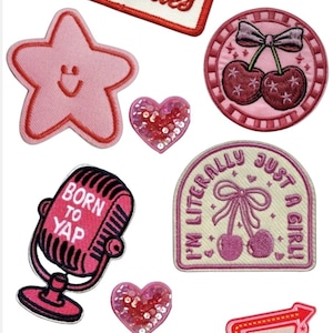 May include: A collection of embroidered patches in various shapes and designs. Includes patches with text like "All Worries", "Born to Yap", and "Perpetually Discobobulated". Other patches feature a star, cherries, and a microphone.