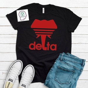 May include: Black t-shirt with a red elephant graphic and the word "delta" in red letters.