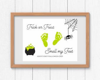 May include: A framed Halloween-themed print with the text "Trick or Treat" and "Smell my Feet." The print features green footprints, a cauldron, a spider, and a spiderweb. The text "Addy's First Halloween 2025" is also included.