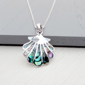 May include: A silver seashell pendant necklace. The pendant features iridescent abalone shell in shades of green, blue, and purple. The necklace has a delicate silver chain.