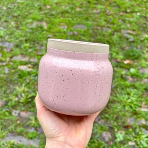 May include: A set of three ceramic mugs with a speckled, matte finish in cream, light grey, and dark grey. Each mug has a simple, minimalist design, suitable for coffee or tea.