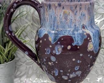 Hand thrown 26 oz tall porcelain mug in crazy double purple and blue glaze.