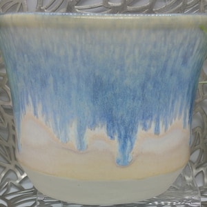 Hand thrown 21 oz porcelain bowl in traditional tea bowl shape in honey cream glaze with blue waterfall, 5 x 3.8.