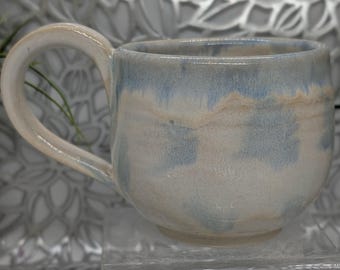 Small 11oz hand thrown footed porcelain coffee cup in honey cream and blue.