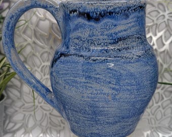 Hand thrown 24 oz tall porcelain mug in variegated dark blue glaze.