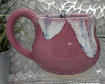 Hand thrown short 18 oz short footed porcelain coffee cup in hot pink opal and white with blue drips.