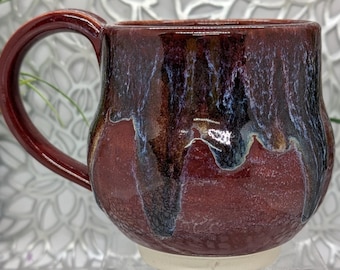 Hand thrown and trimmed 16 oz footed short porcelain coffee cup in imperial red and dazzling blue glaze combination.