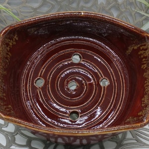 Hand Thrown  rectangular ridged soap dish with five drain holes in fiery red and gold, 4.5x5.75x.2.5. Four small ball feet.