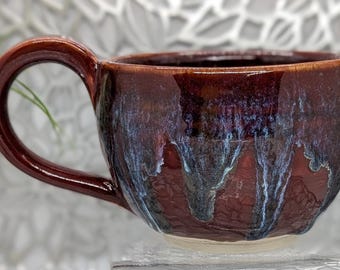 Hand thrown 16 oz footed porcelain coffee cup in imperial red, violet, and blue glaze combination.