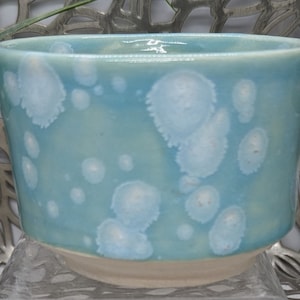 Hand thrown 11 oz traditional footed tea bowl in pale green celadon with white color bursts, 3.8x2.75