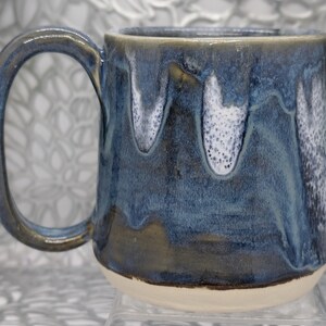 Hand thrown 20 oz cone coffee cup in earth tone blue and mottled white glaze.