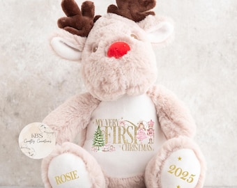 May include: A plush reindeer toy with a light pink body, brown antlers, and a red nose. The reindeer has the text "MY VERY FIRST CHRISTMAS" and the name "Rosie" embroidered on it. The year "2025" is also embroidered on the foot.