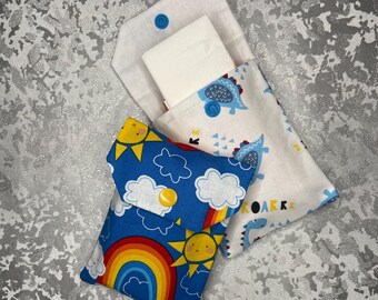 May include: Two fabric pouches with different designs. One pouch is blue with a rainbow, clouds, and suns. The other pouch is white with blue dinosaurs and the word "Roar". Both pouches have a button closure.