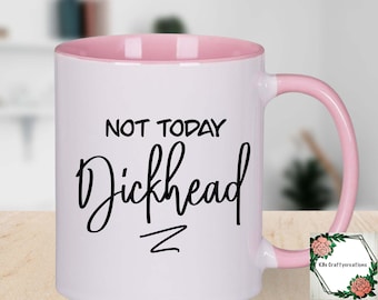 May include: White ceramic mug with a pink rim and handle. The mug has black text that reads "Not Today Dickhead" with a squiggly line underneath.