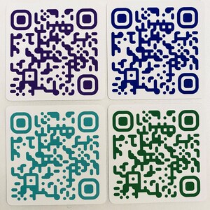 May include: Four square QR code stickers in shades of purple, blue, teal, and green. Each sticker has a white background with a colored border and a unique QR code pattern in the same color as the border.