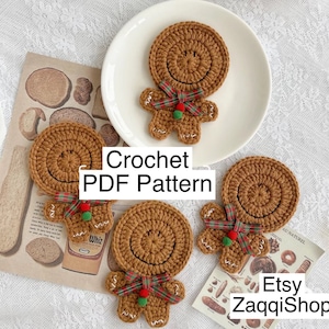 Puede incluir: Tres adornos de jengibre tejidos a crochet en un plato blanco. Los adornos son marrones con detalles rojos y verdes. El texto "Crochet PDF Pattern" está escrito en blanco sobre fondo negro. El texto "Etsy ZaqqiShop" está escrito en blanco sobre fondo negro.
