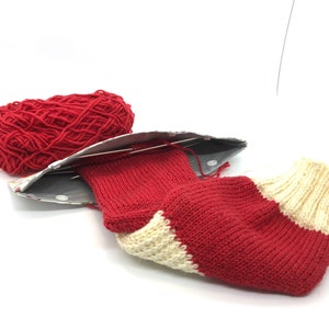 May include: A red and white striped knitted sock with a ball of red yarn and knitting needles.