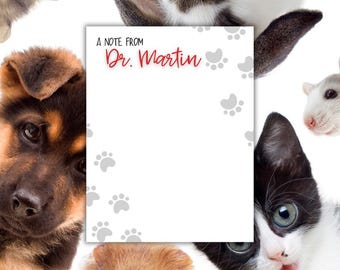 May include: A white note pad with a gray paw print pattern and the text "A Note From Dr. Martin" in red. The note pad is surrounded by various pets, including a dog, cat, rabbit, guinea pig, and rat.