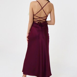 May include: A long, burgundy satin dress with a criss-cross lace-up back.