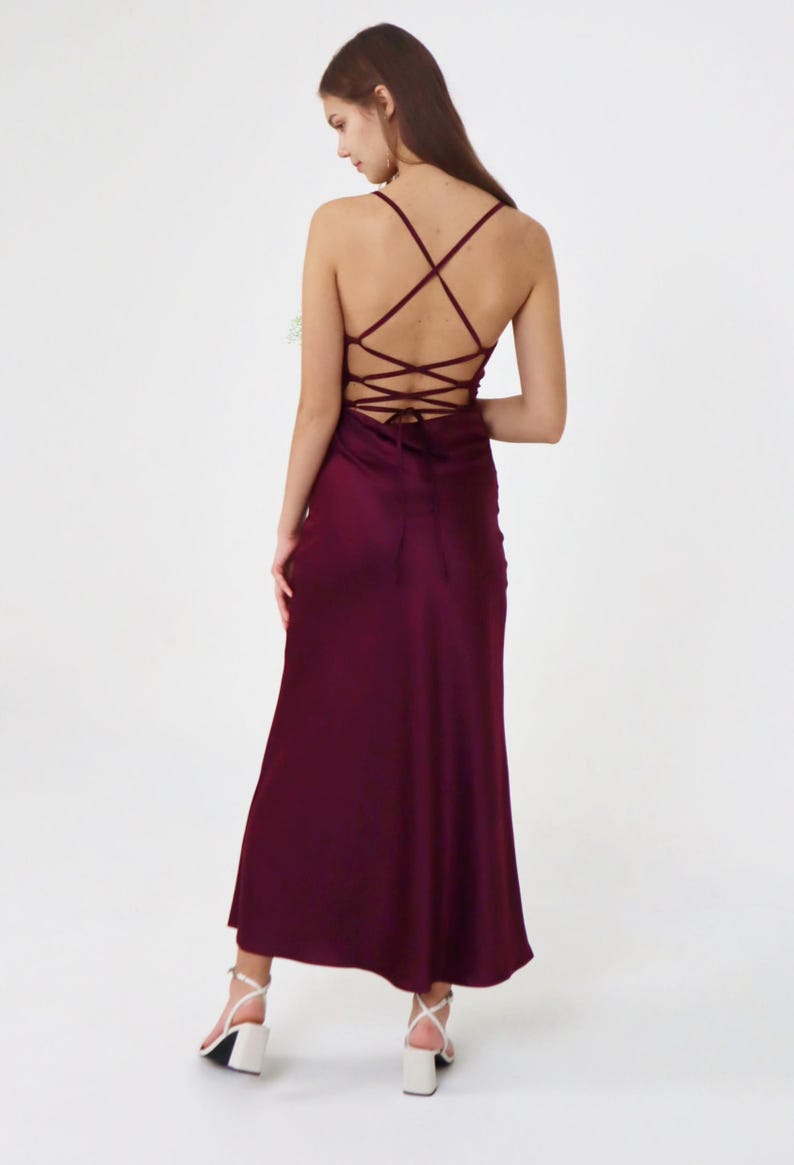 May include: A long, burgundy satin dress with a criss-cross lace-up back.