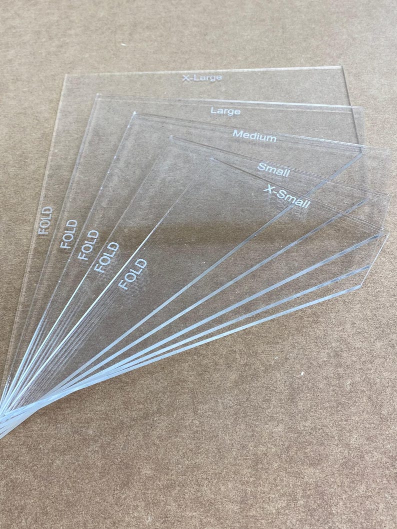 May include: Six clear plastic sheets with the words "FOLD" printed on the side. The sheets are labeled with different sizes: X-Large, Large, Medium, Small, and X-Small.