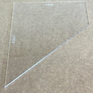 May include: A clear plastic ruler with a diagonal fold line. The ruler is labeled "Large" and "FOLD".