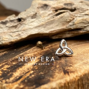 May include: Silver Celtic knot charm, a traditional symbol of love, friendship, and eternity. The knot is a three-dimensional design with a smooth, polished finish.