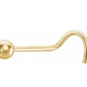 May include: A gold nose ring with a small ball at the end.