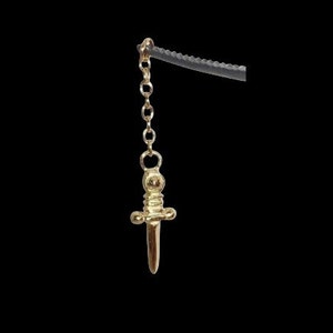 May include: A gold chain necklace with a dagger pendant. The dagger is detailed with a round top and a pointed tip.