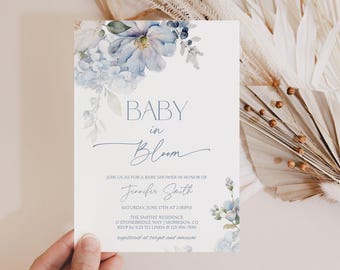 Peut inclure: Une carte d'invitation rectangulaire blanche pour une fête prénatale avec des illustrations florales aquarelles bleues. Le texte indique : BABY in Bloom, JOIN US AS FOR A BABY SHOWER IN HONOR OF Jennifer Smith, SATURDAY, JUNE 17TH AT 2:00PM, THE SMITHS' RESIDENCE, 17 STONEBRIDGE WAY | MORRISON, CO, RSVP by 5/23 TO LINDA @ 123-456-7890, registered at target and amazon.