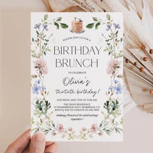Puede incluir: Invitación a un brunch de cumpleaños con detalles florales. La tarjeta anuncia "BRUNCH DE CUMPLEAÑOS" para celebrar el trigésimo cumpleaños de Olivia. El diseño incorpora flores y follaje en acuarela, con una ilustración de panqueque en la parte superior.