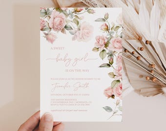 Könnte beinhalten: Eine Babyparty-Einladung mit floralem Design. Die Einladung zeigt rosa Rosen und grüne Blätter. Der Text lautet "A sweet baby girl is on the way" und enthält Eventdetails.