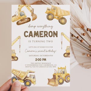 May include: A birthday invitation with watercolour illustrations of yellow construction vehicles, such as a dumper truck, excavator, and crane. The text reads "dump everything CAMERON IS TURNING TWO" and includes party details.