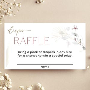 May include: A white diaper raffle card with the words "diaper RAFFLE" in a script font. The card includes text inviting guests to bring diapers for a chance to win a prize. Floral accents and a line for a name are also included.