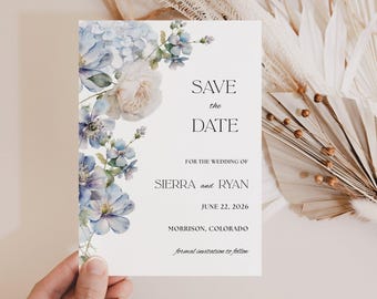 Puede incluir: Una tarjeta rectangular de Save the Date con ilustraciones florales en acuarela azul y blanca en el lado izquierdo. El texto dice: SAVE the DATE FOR THE WEDDING OF SIERRA and RYAN JUNE 22, 2026 MORRISON, COLORADO formal invitation to follow.