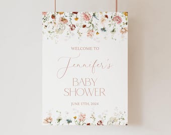 May include: A rectangular sign with a white background featuring watercolor floral illustrations in shades of pink, red, and green at the top and bottom. The text reads: WELCOME TO Jennifer's BABY SHOWER JUNE 17TH, 2024 in pink lettering.