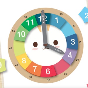 May include: A colorful educational clock with a cat face design. The clock face is divided into segments of various colors, each representing an hour. The minute and hour hands are gray. Includes separate number tiles.