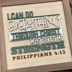 Peut inclure: Panneau en bois encadré avec les mots "I CAN DO EVERYTHING THROUGH CHRIST WHO GIVES ME STRENGTH PHILIPPIANS 4:13". Le texte est de différentes couleurs, dont le blanc, le vert et le marron, sur un fond en bois clair.