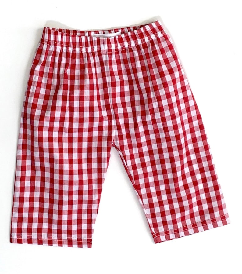 May include: Red and white gingham checkered shorts with an elastic waistband.