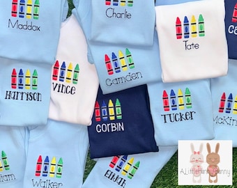 ¡Nuevos colores! Envío rápido. Reposición de stock. Camiseta de regreso a clases con bordado de crayón personalizado. Pantalones cortos de cuadros opcionales. Tallas para bebés, niños pequeños y jóvenes.